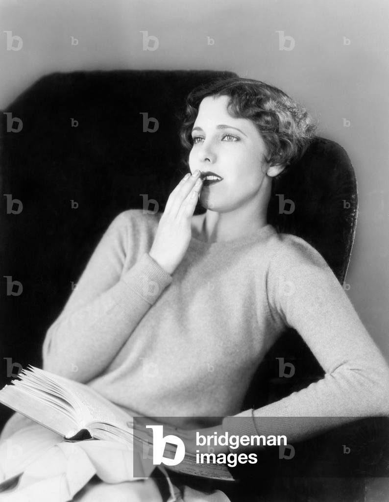 Young Woman Sitting on a Armchair with a Book