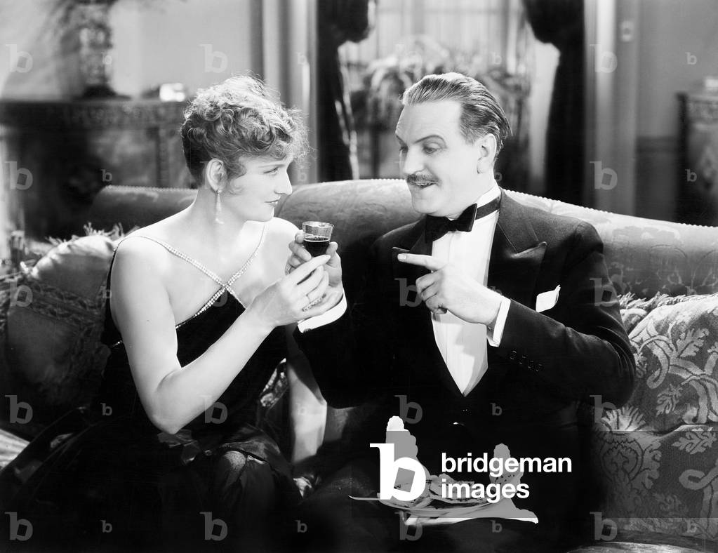 Couple Sitting Together on a Sofa and Having a Drink