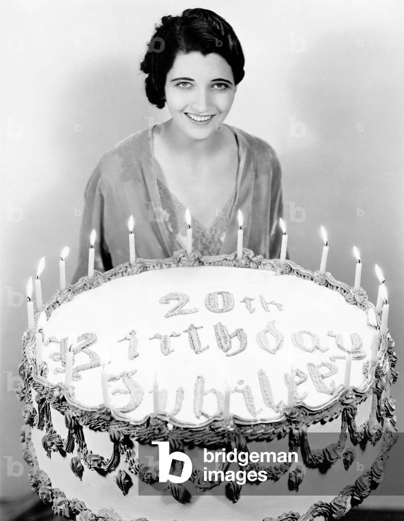 Portrait of a Young Woman Standing in Front of a Birthday Cake