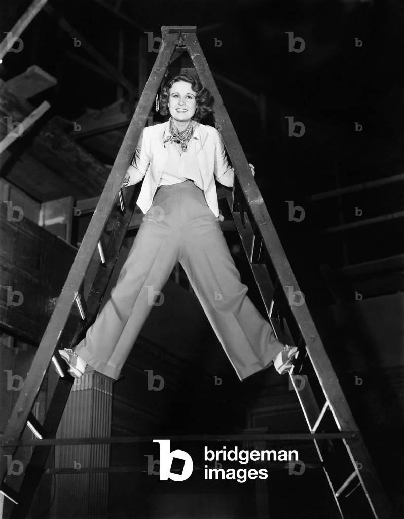 Young Woman Climbs a Ladder to the Top