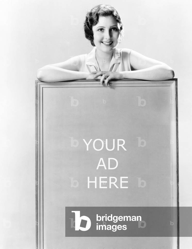 Young Woman Standing Behind a Sign
