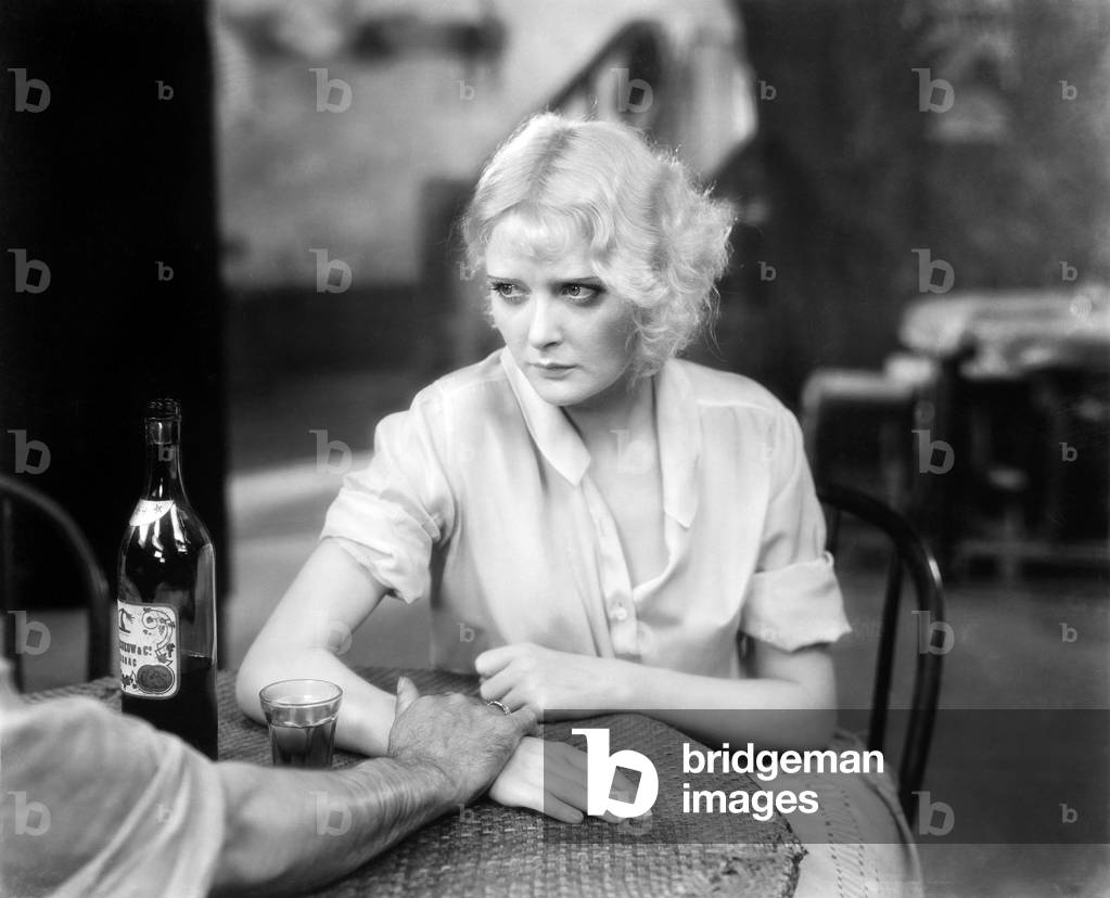 Woman Sitting with a Person in a Restaurant Looking Upset