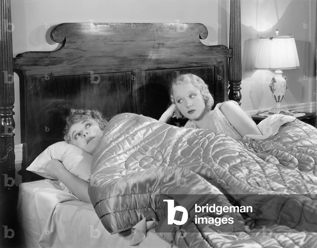 Two Women Together in Bed Under a Blanket
