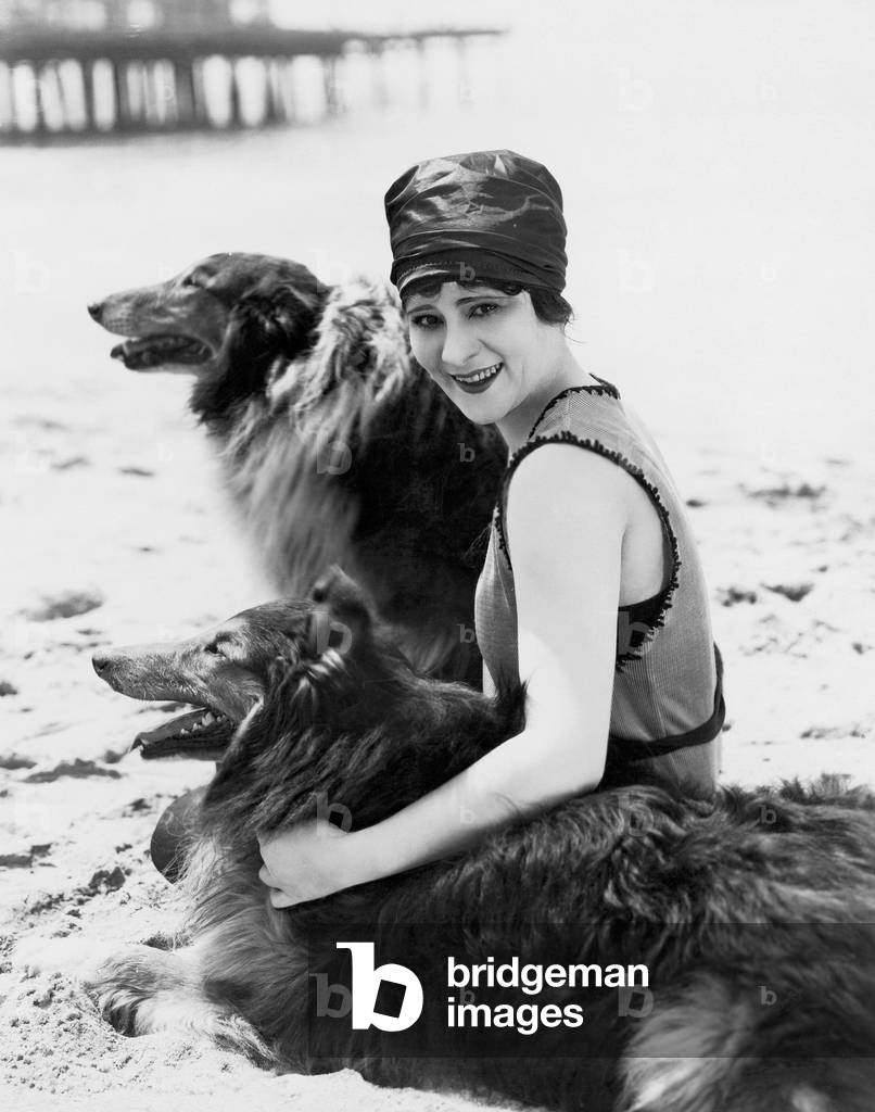 Young Woman Sitting with her Collies on the Beach