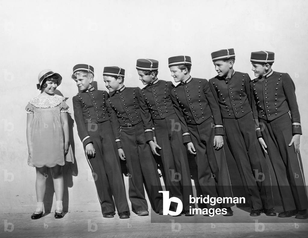Line of Young Bellhops Smiling at Girl