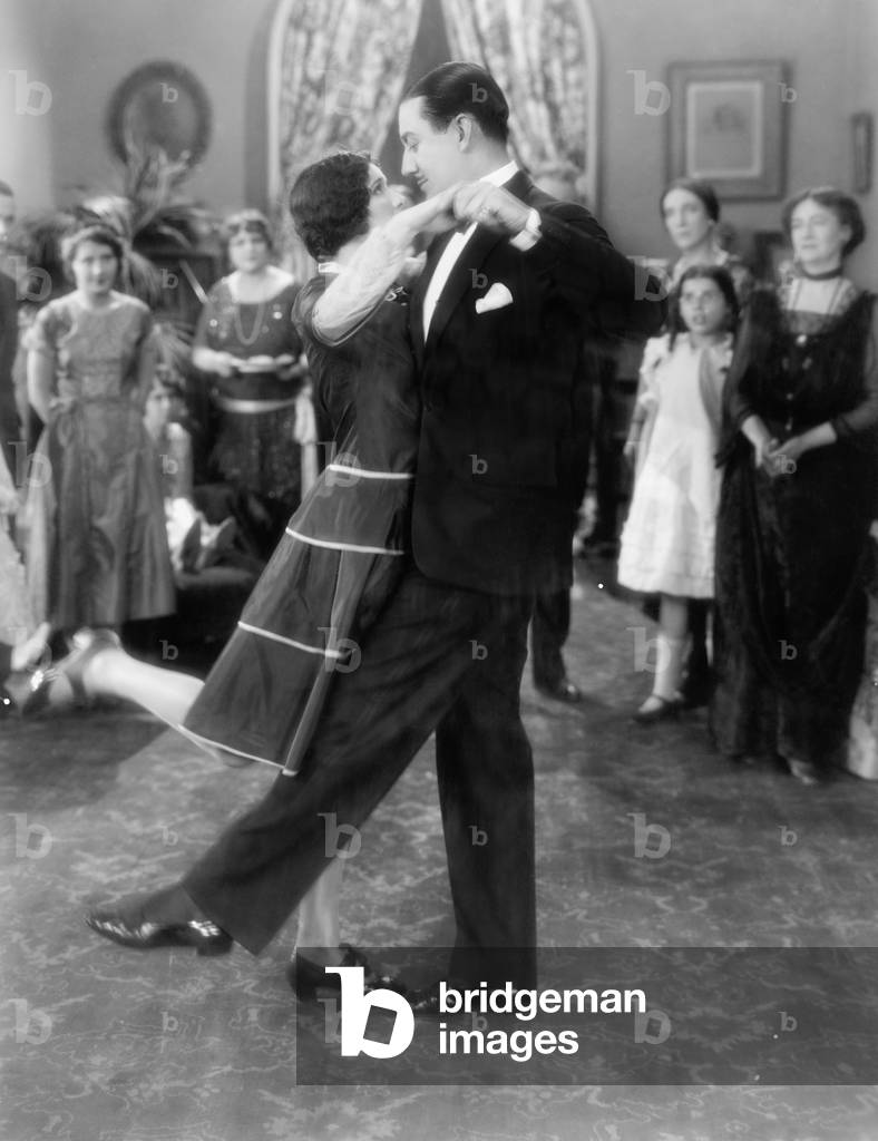 Couple Dancing Lightly While Others are Watching
