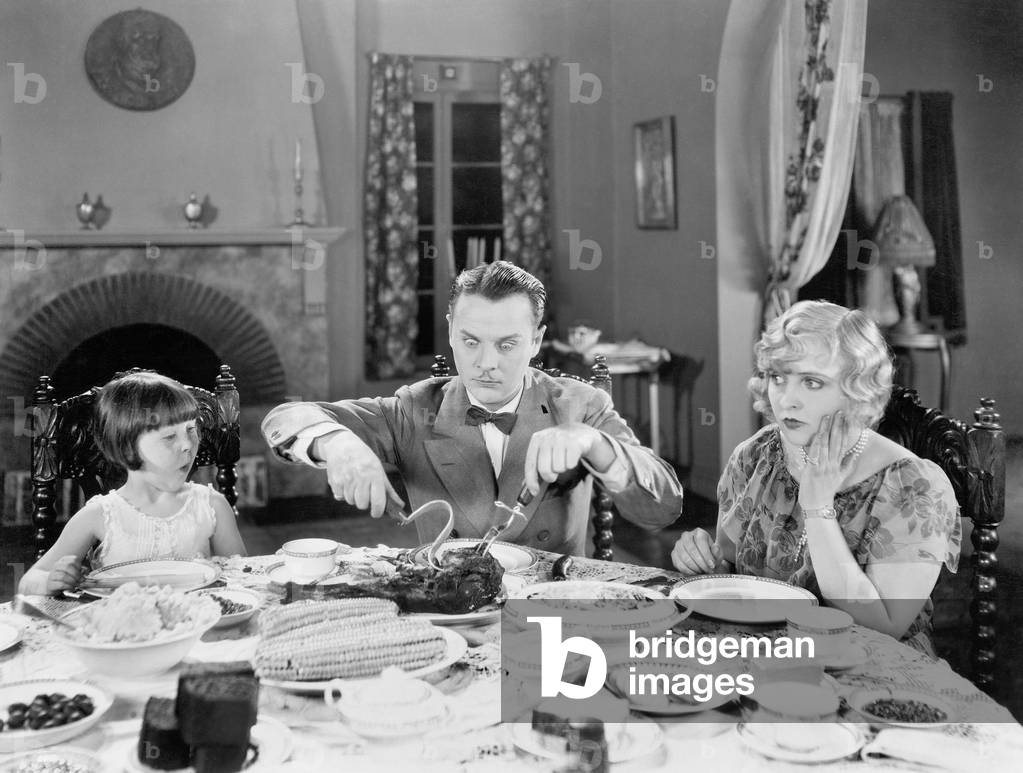 Family of Three Sitting Together Having Dinner