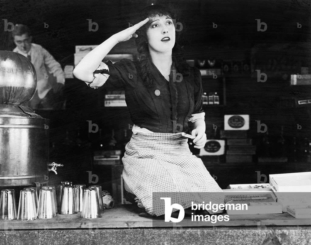 Woman Kneeling on the Counter of a Bar and Saluting