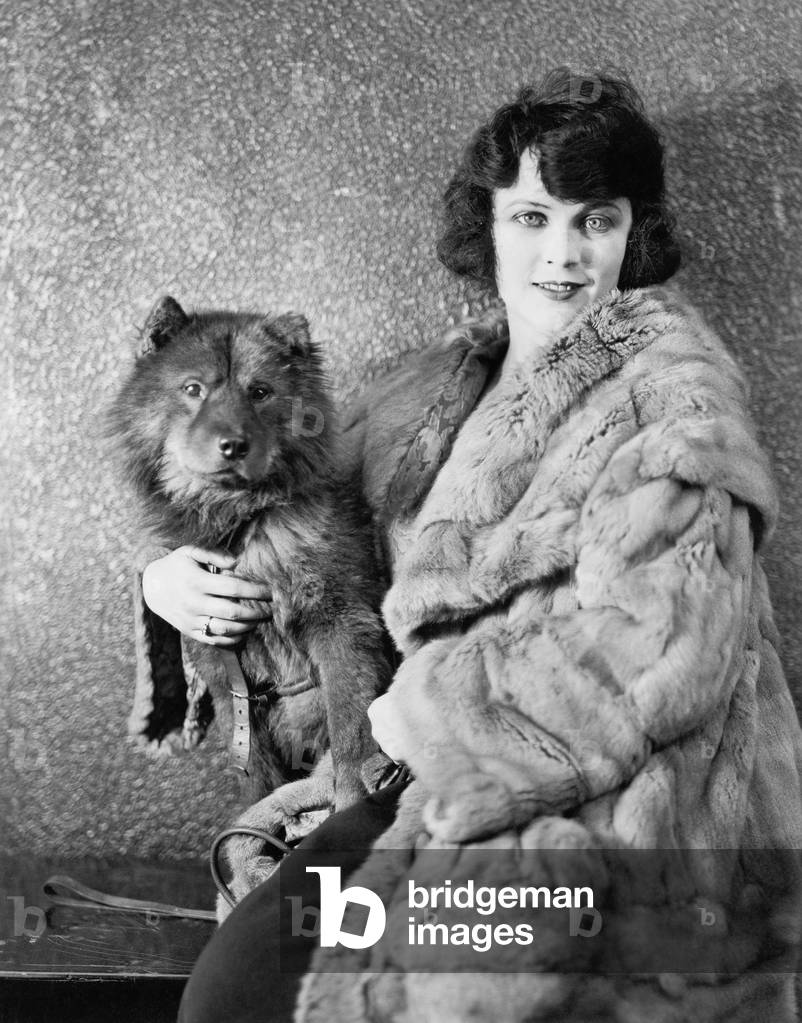 Woman in her Fur Coat Sitting with her Dog