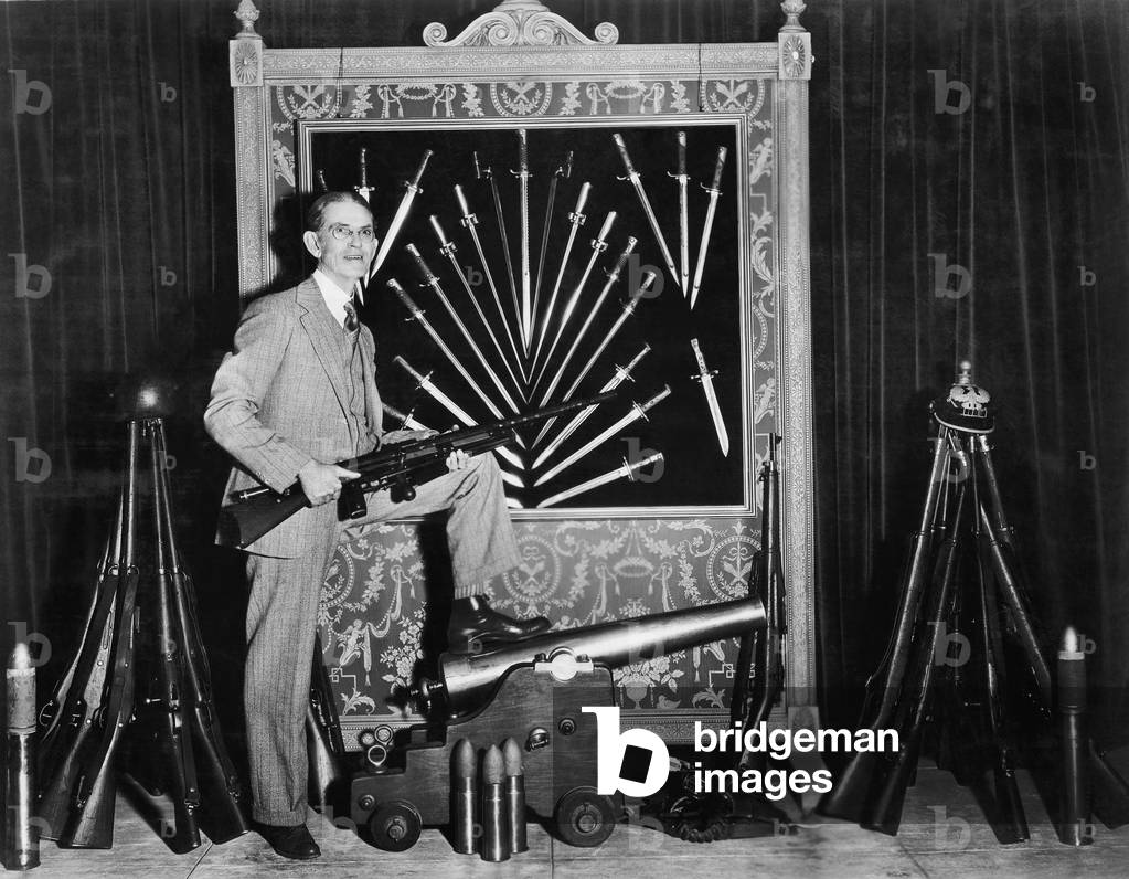 Man Posing with Guns and Cannons