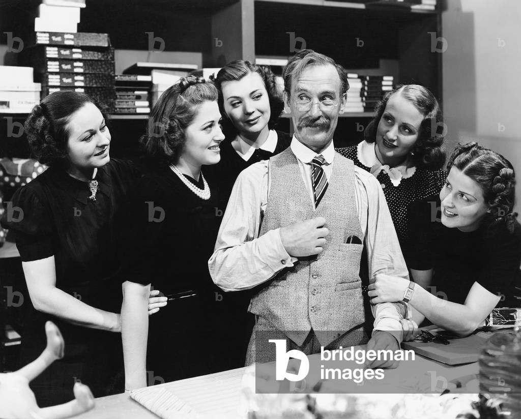 Five Young Women Gathering Around a Salesman in a Store
