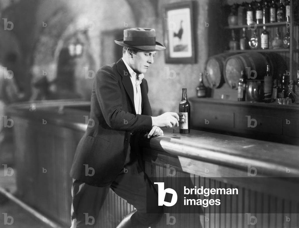 Lonely Man Standing at a Bar Counter with a Drink