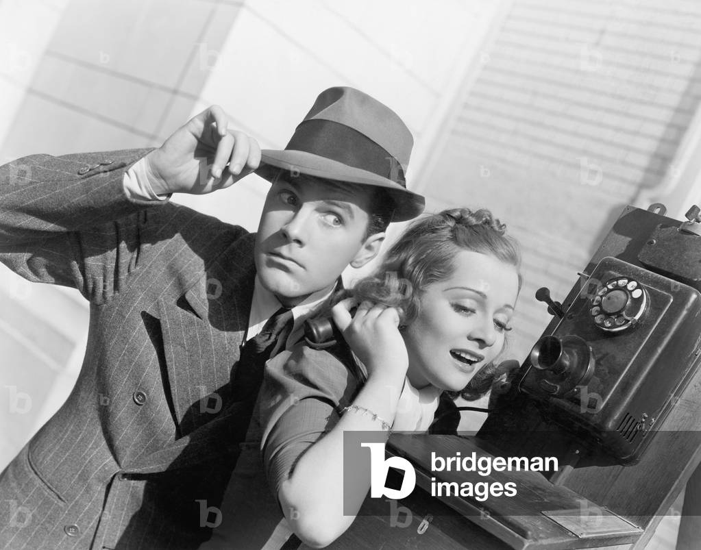Man and Woman Listening on an Outside Telephone