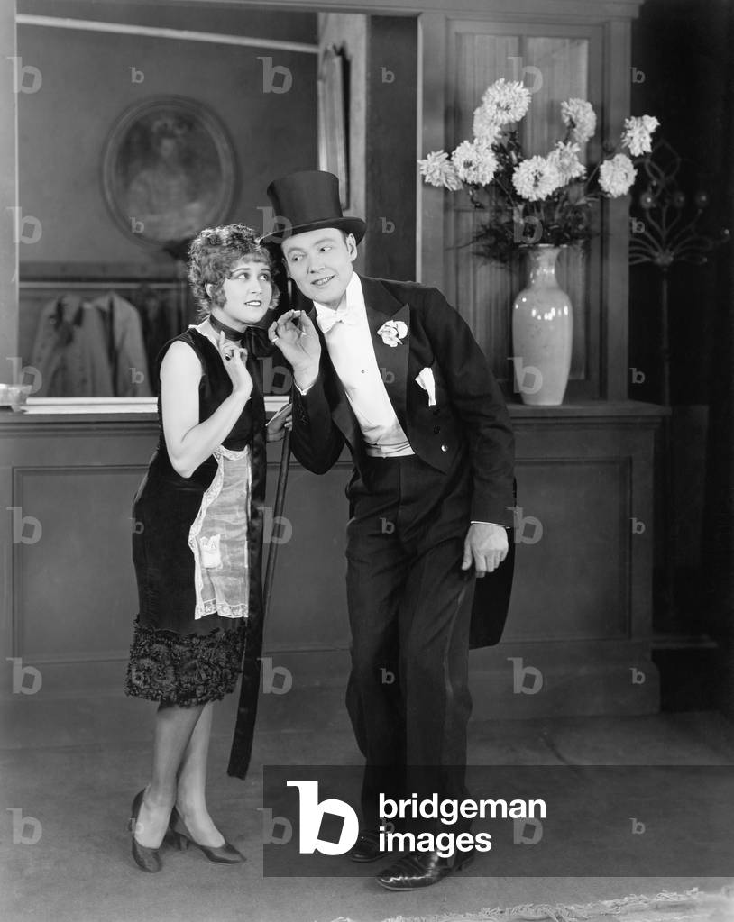 Coat Clerk Whispering to a Man in a Top Hat