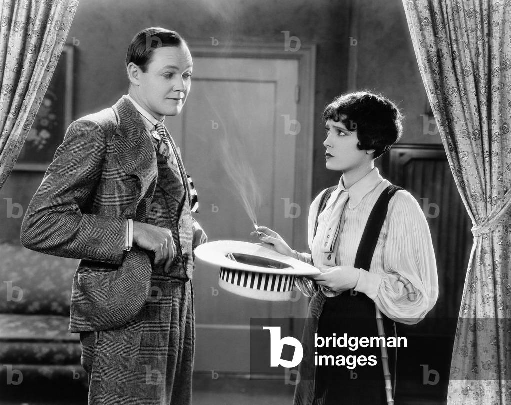 Woman Holding Hat and Smoking Interacting with Man