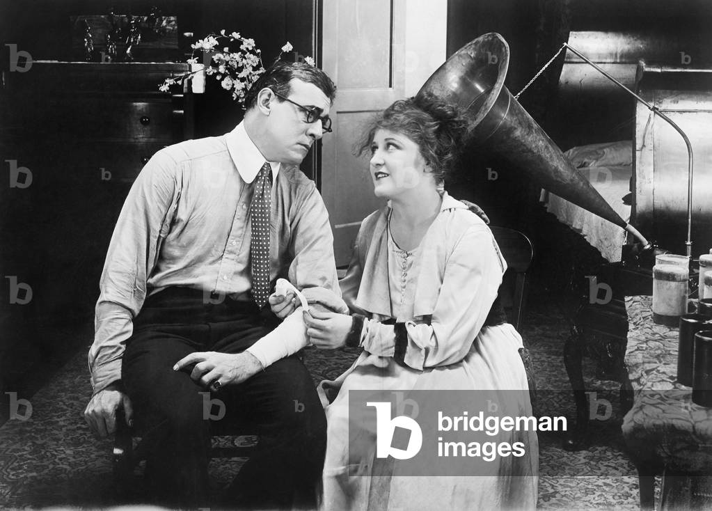 Woman Tending to a Man By Placing a Bandage on his Arm