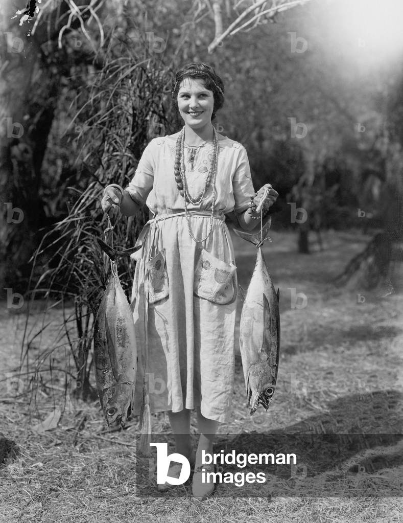 Young Woman Holding Two Huge Fish