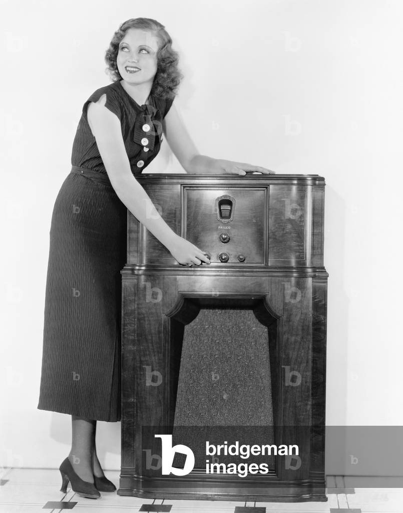 Woman Next to a Radio Turning the Knobs