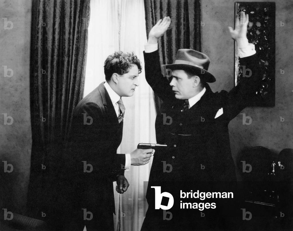 Armed man holding up man in hat