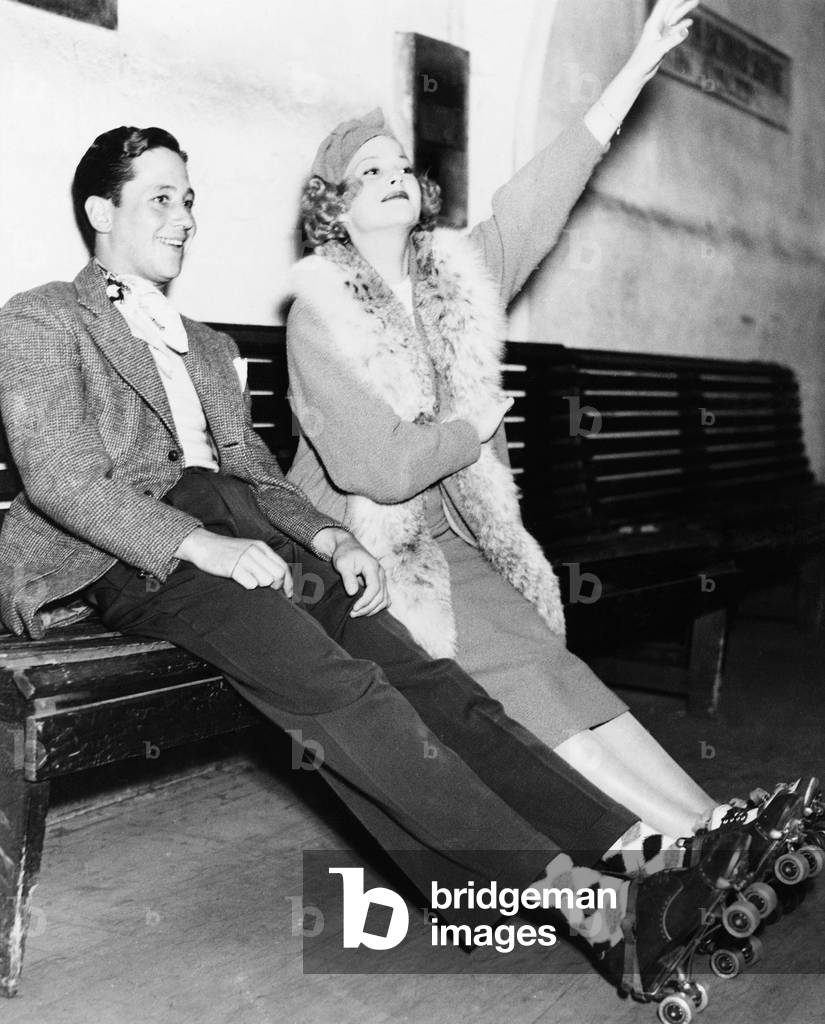 Couple Wearing Roller Skates and Sitting on a Bench