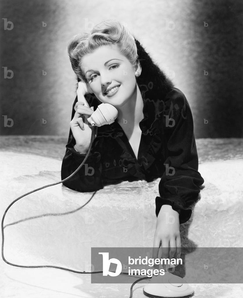 Young Woman Lying on her Stomach and Talking on the Telephone