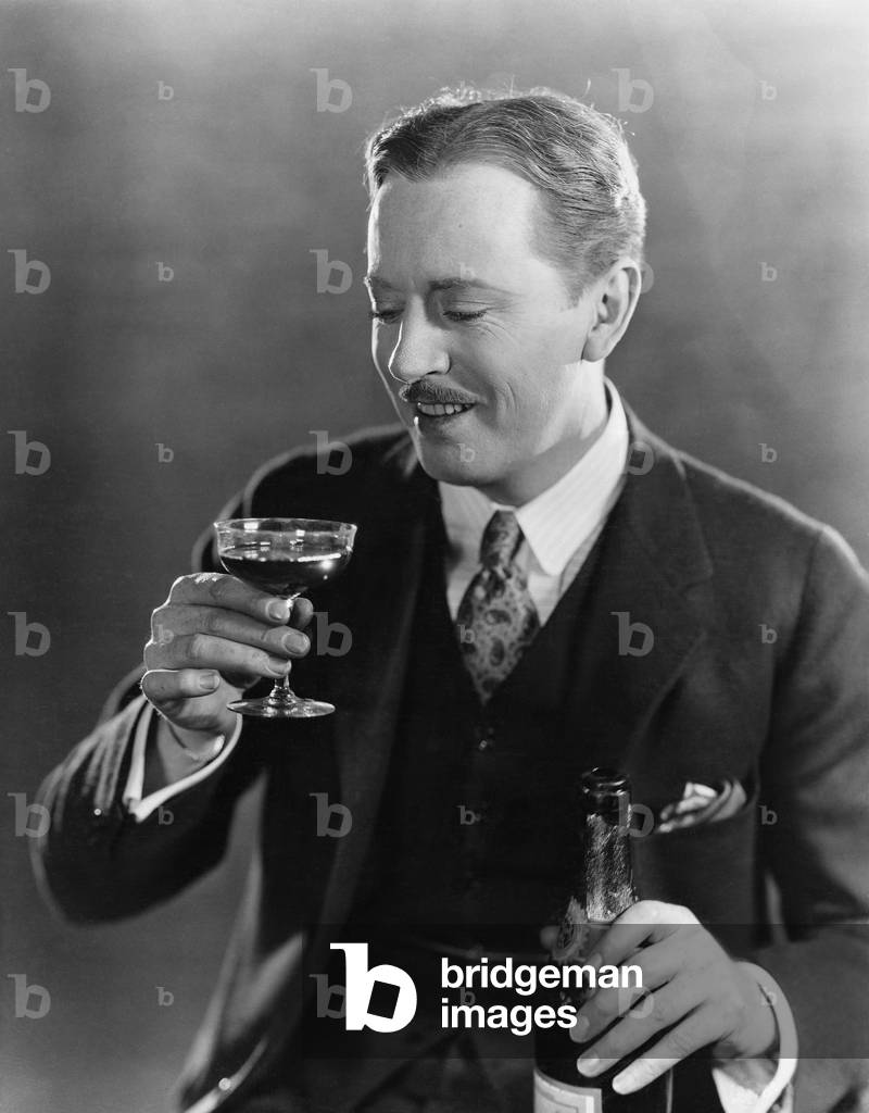 Smiling Man with Beverage and Bottle