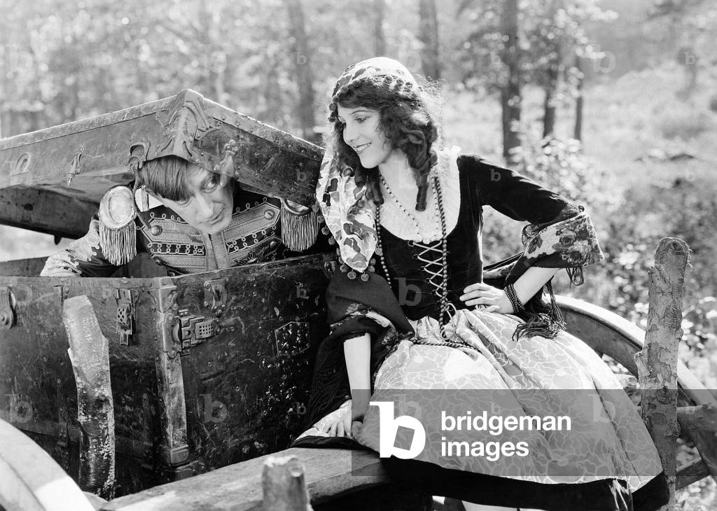 Smiling Woman with Soldier Emerging From Trunk