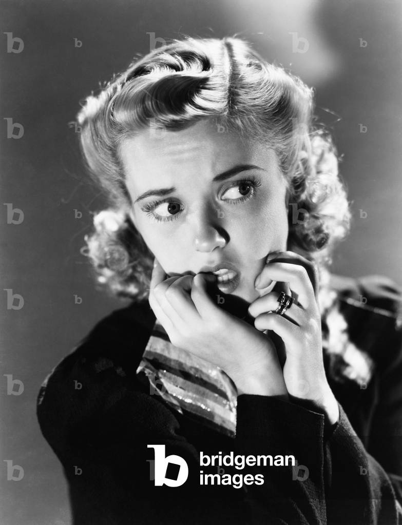 Portrait of a Young Woman Biting her Nail and Looking Frightened