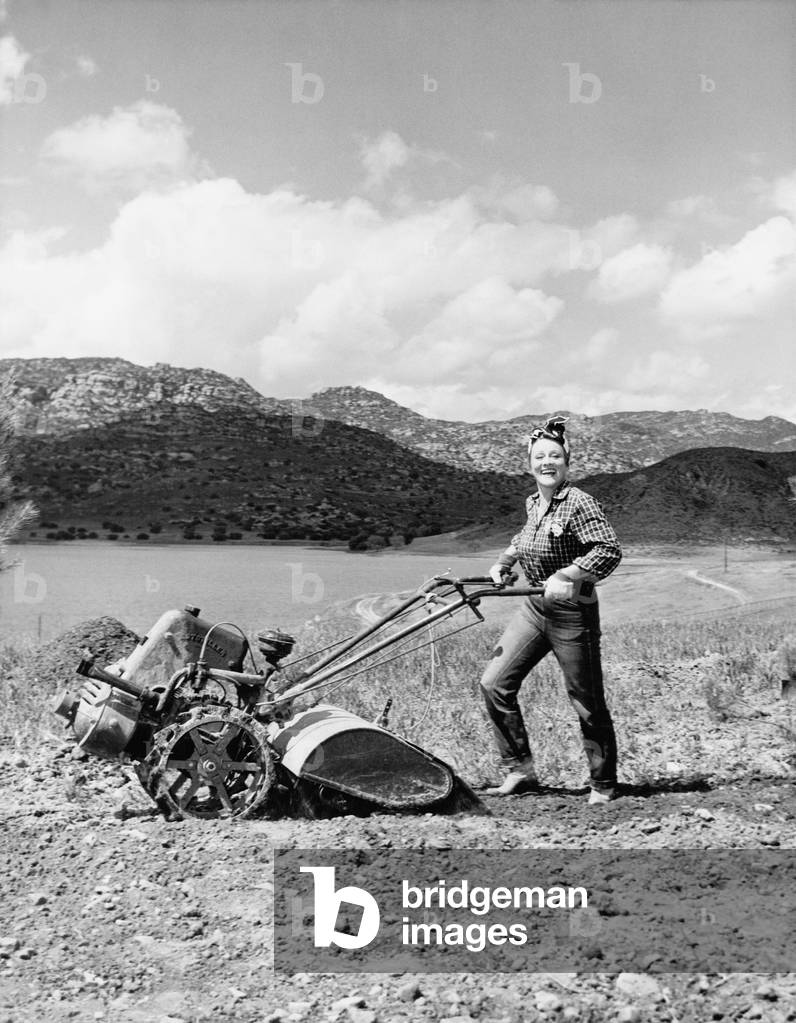 Young Woman on a Field Using a Lawn Mower
