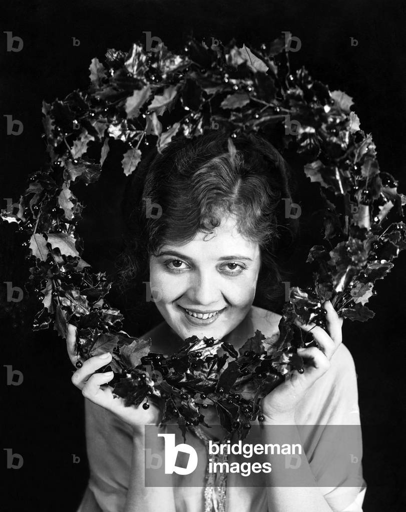 Portrait of Woman Holding Christmas Wreath
