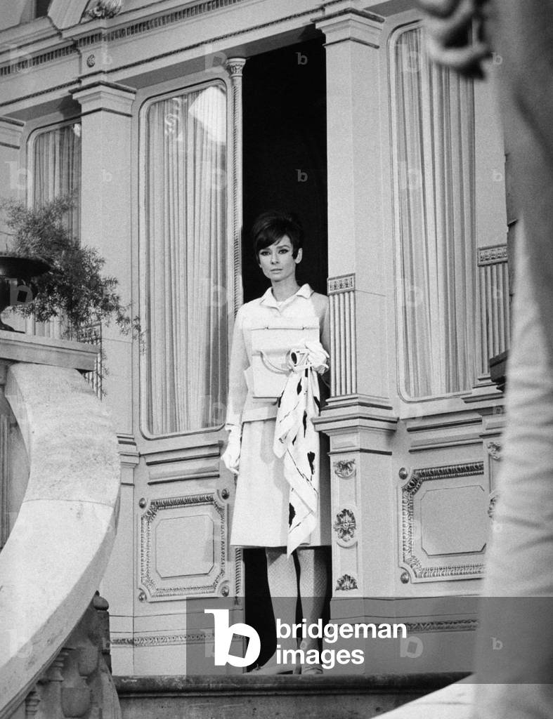 Audrey Hepburn is going out of a door with a worried expression