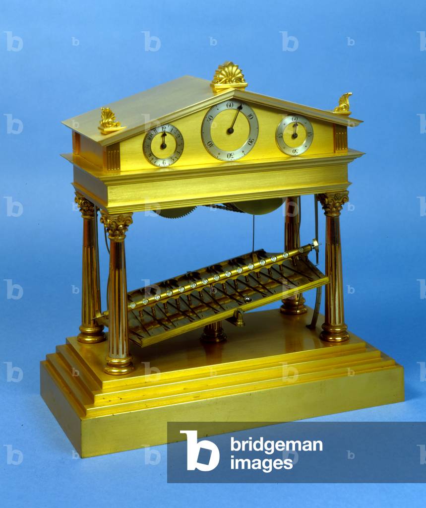 Rolling-ball clock, escapement operated by a ball rolling down a zig-zag path cut in a plate pivoted at its centre, housed in a brass cover in the form of a Greek Temple, holding three dials in the pediment, English, by E. Dent & Co, c.1920