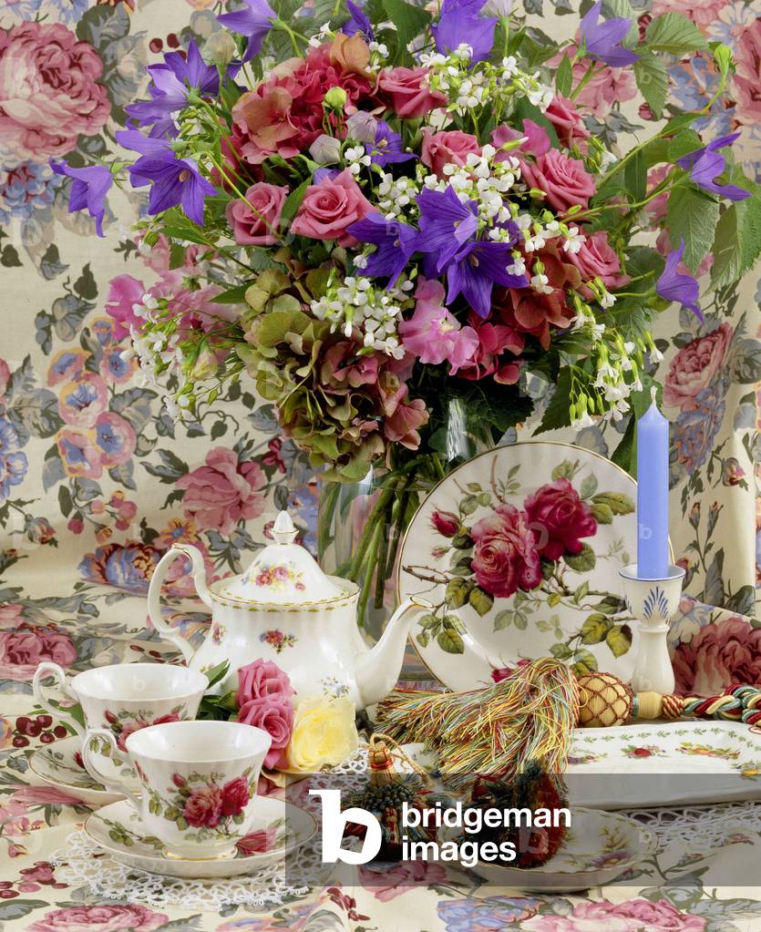 Still life of flowers with service and candles.