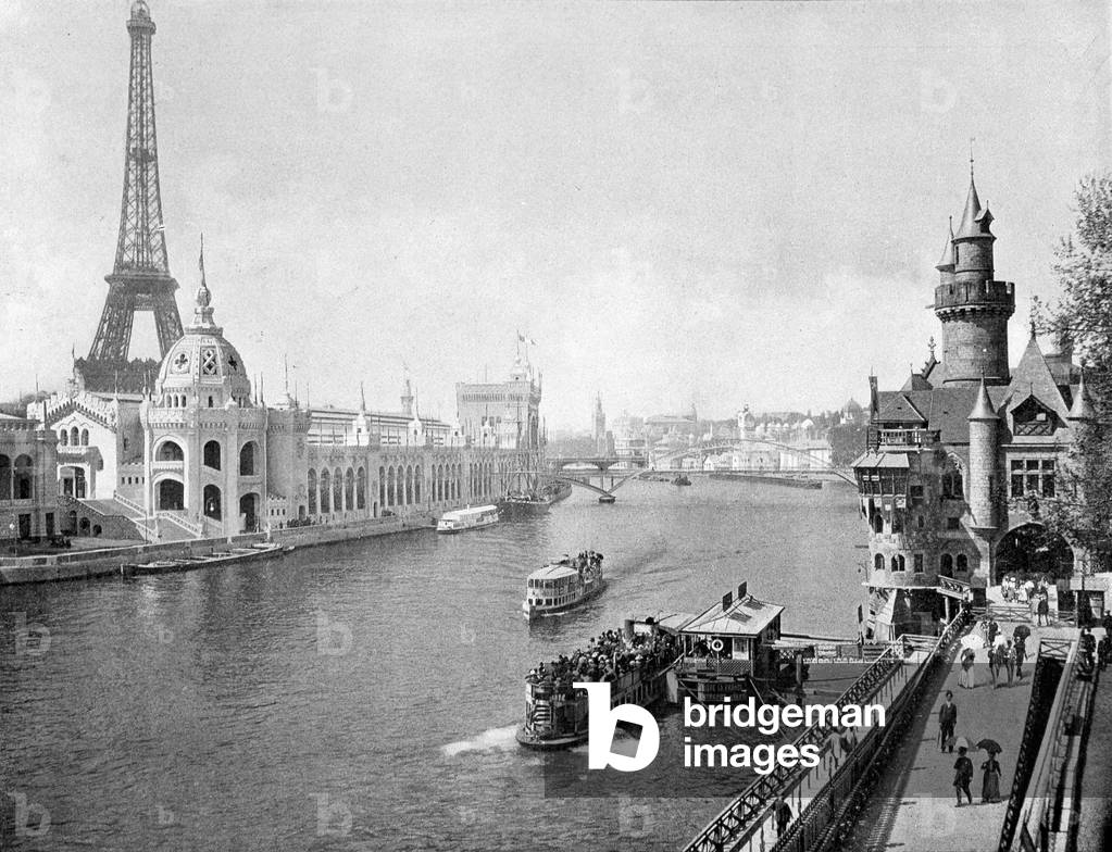 View of the 1900 Universal Exhibition taken from the Pont de l'Alma sur la Seine. On the left, the palace of hygiene and armees. On the right: the gate of Saint Michael and the tower of the Giralda. - in “” The Panorama of the Universal Exhibition of 1900””.