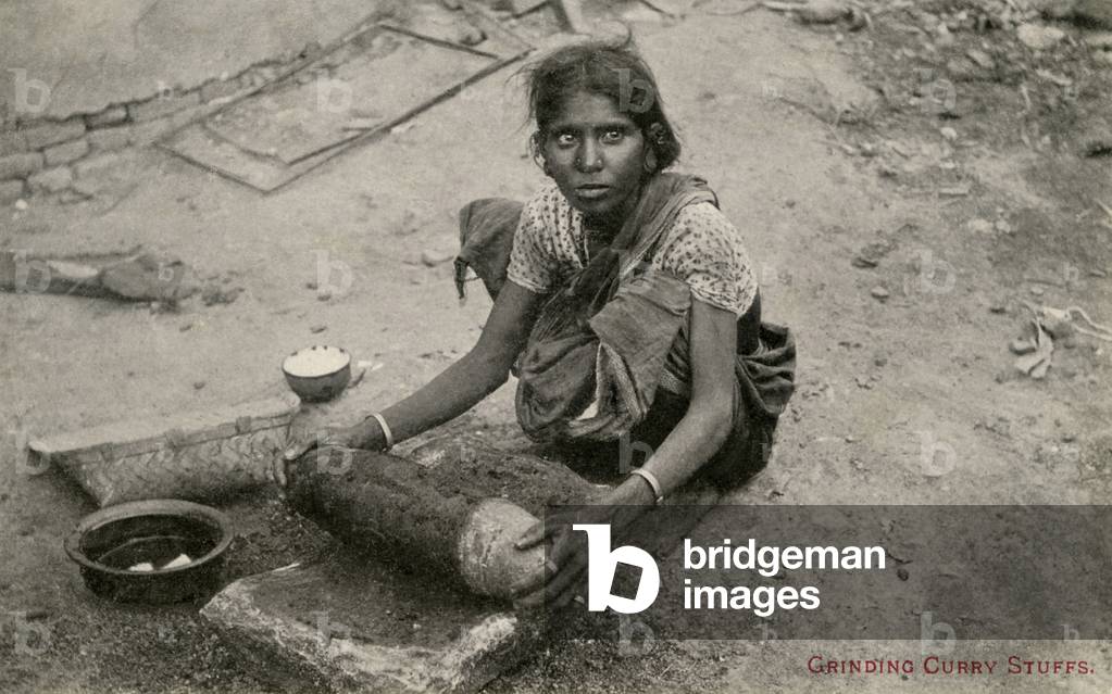 Indian woman grinding curry stuffs