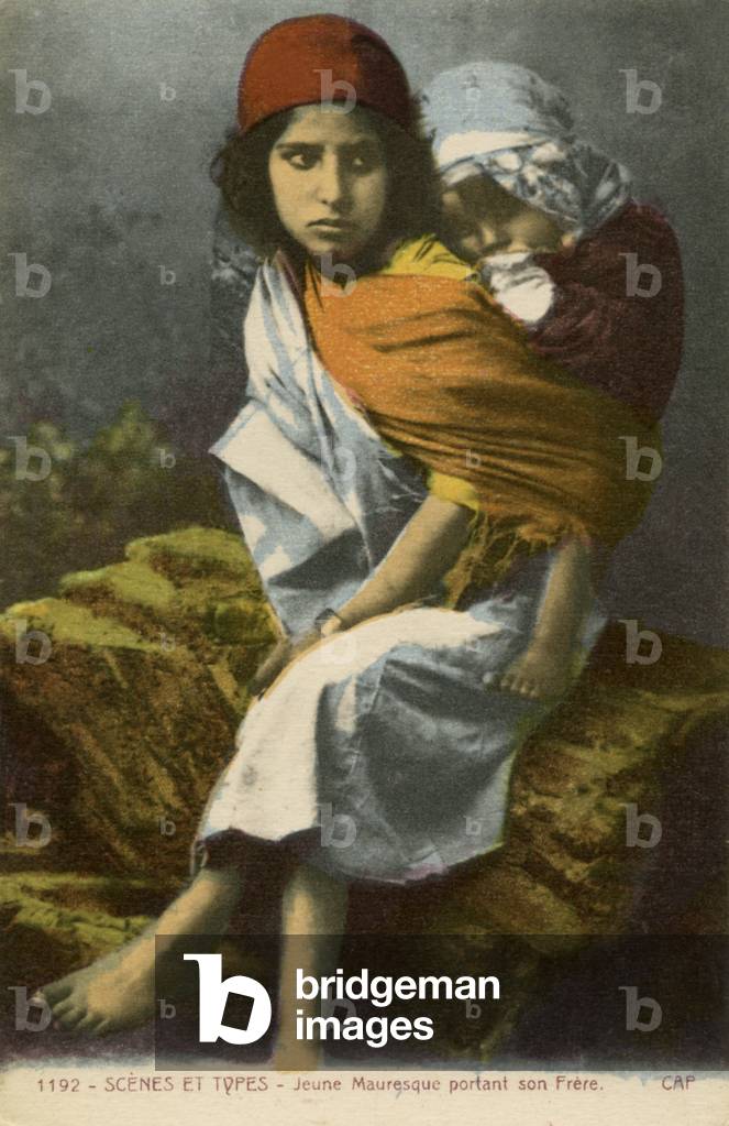 Moroccan girl carrying her younger brother