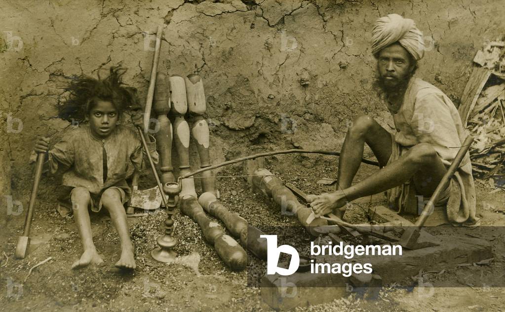 Carpenter and child working on bed legs