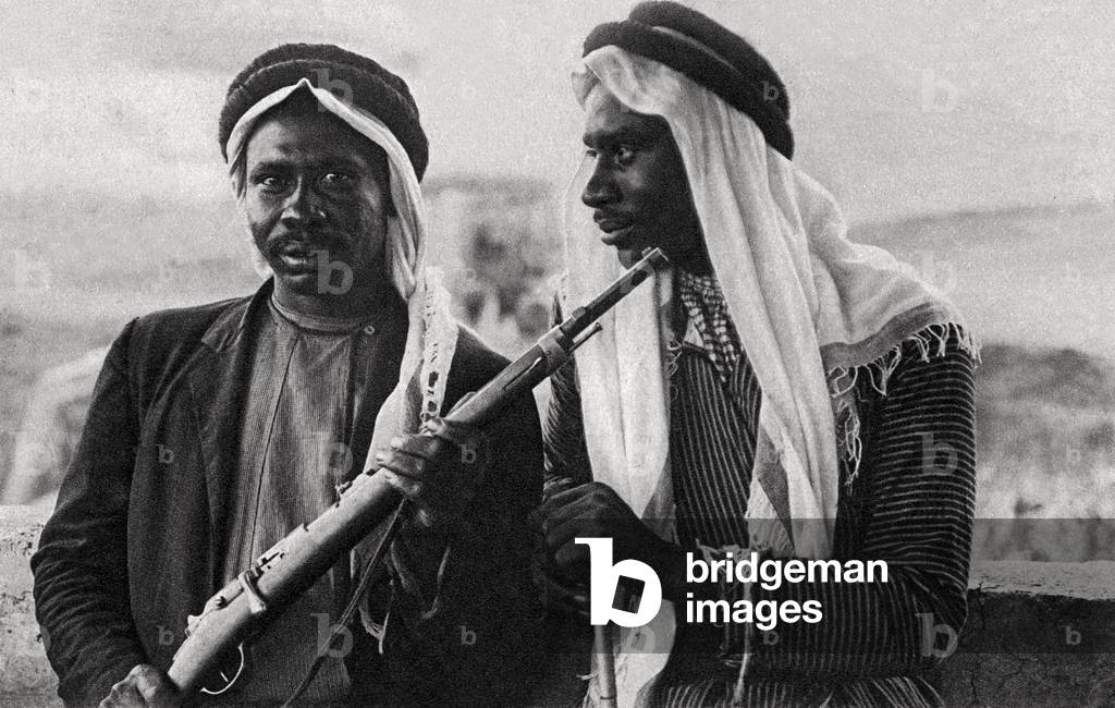 Two bedouins with rifle, 1940s (photo)