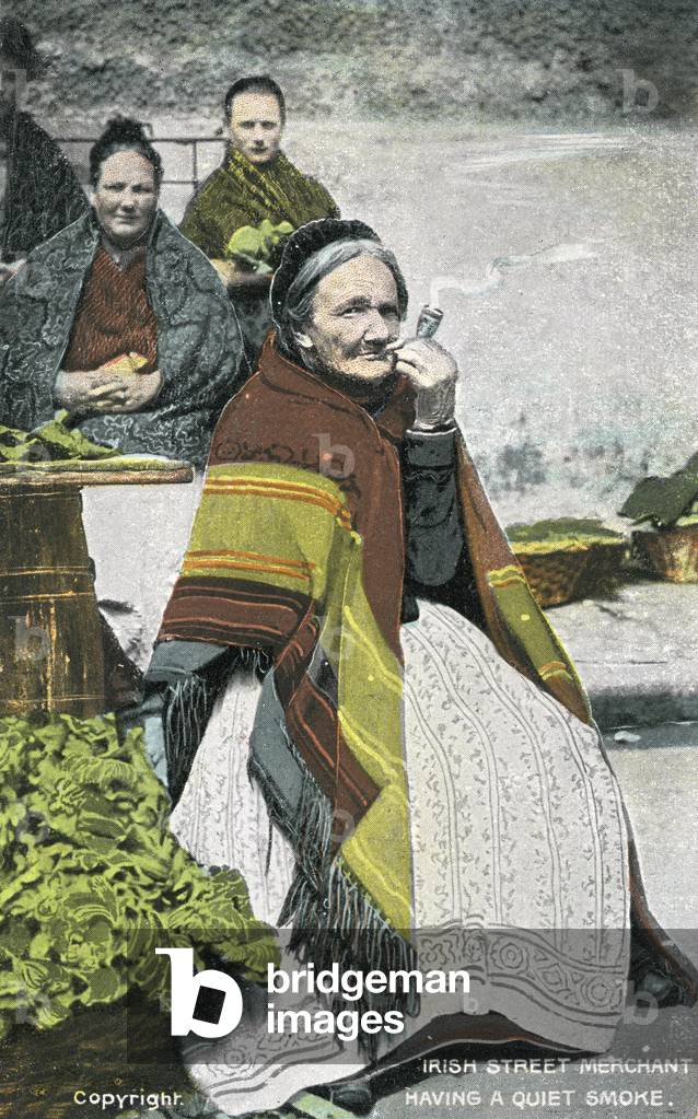 Irish street merchant smoking a pipe, 1900s postcard