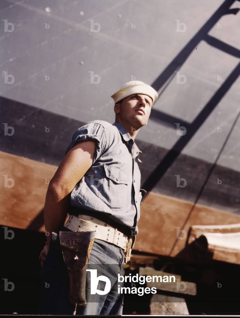 Coast Guardsman standing watch over 78-foot torpedo boat. Continual watch is kept. Higgins Industries, Inc., New Orleans, Louisiana, July 1942 (photo)