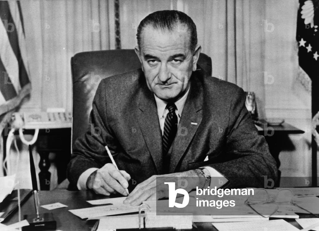 President Lyndon B.Johnson making an absentee ballot in his White House office, 1963 (b/w photo)