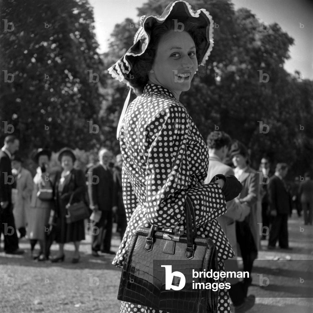 Fashion in Longchamp, Paris, May 9, 1948 : Elegant Woman Wearing A Polka Dot Dress and A Hat (b/w photo)