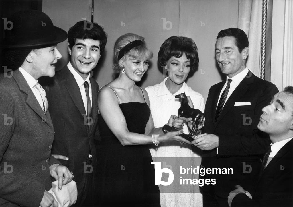 On the occasion of the 50th Representation Of Gabybruyere Piece “Les Cavaleurs” At the Theatre De La Potiniere Sous Le Regard D'Yvonne Clech Gaby Bruyere (Left) Offering The Bronze Statuette Symboising The Horse “Gladiator” To Pierre Jonqueres D'Oriola On December 1st 1964 (b/w photo)