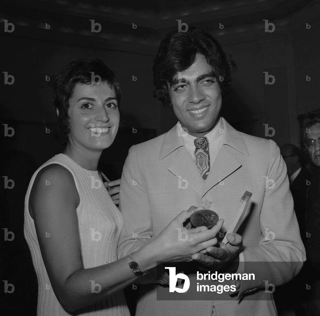 French singer Enrico Macias (right) showing his wife Suzy (left) the 'Shalom' (peace) medal received from Israel Tourist Office Manager Mr Vidar, in Paris on June 24, 1970