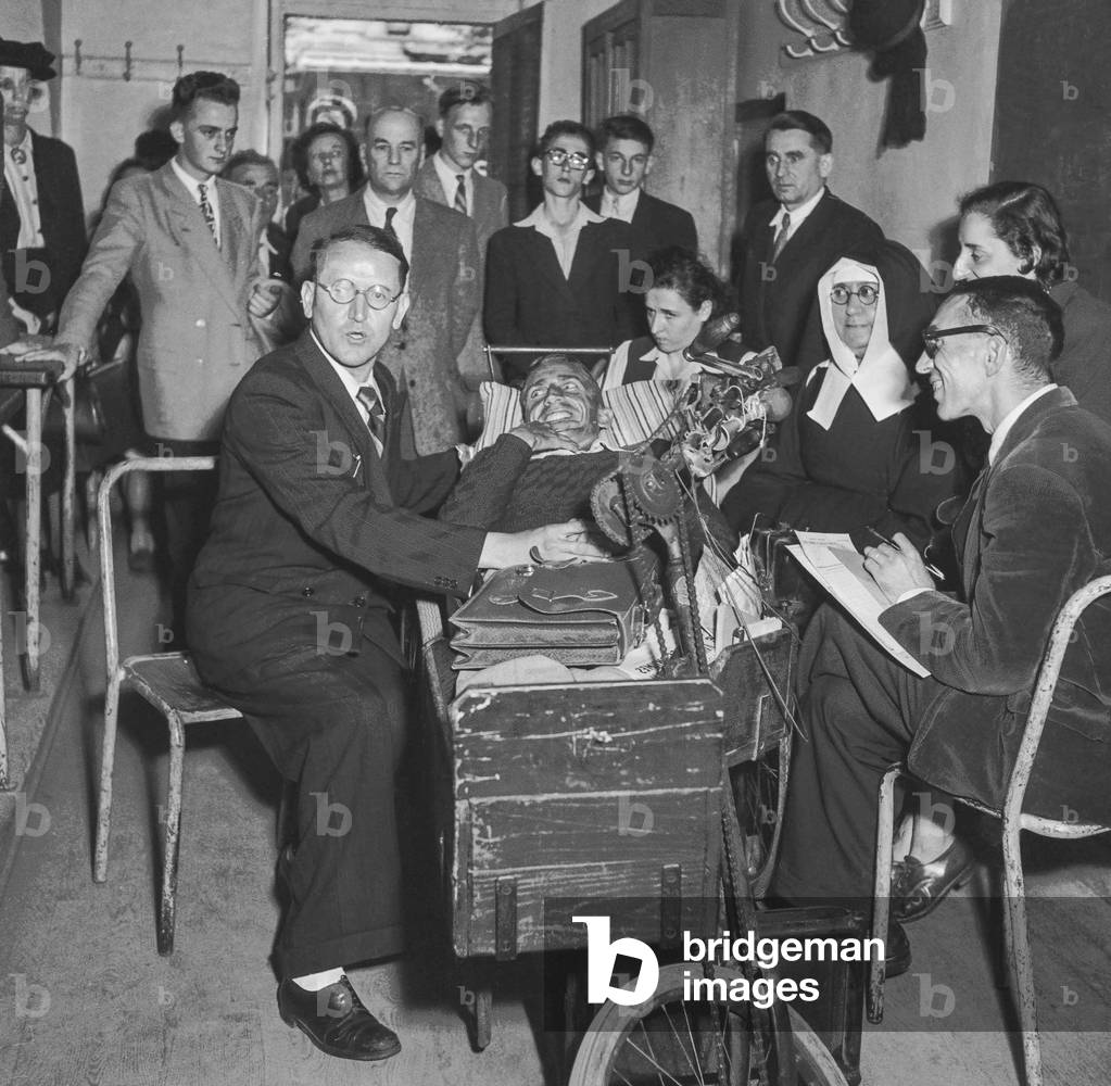 Mr Donzel (l) blind, deaf, almost dumb during baccalureat examination helped by Robert Gressin (disabled, c) who is his interpreter, Paris, July 12, 1950 (b:w photo)