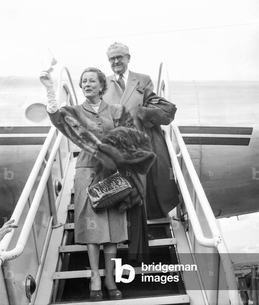American artist Irene Dunne arriving in Paris here at Orly airport, with her husband Francis Griffin, August 30, 1951 (b/w photo)