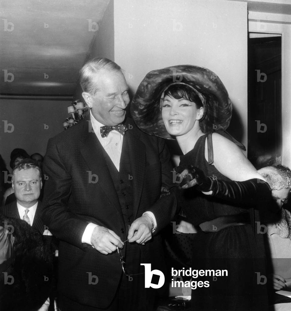 Showing of Hats By Jean Barthet : here Maurice Chevalier and Model Lucie Daouphars, Called Lucky, on January 20, 1962 (b/w photo)