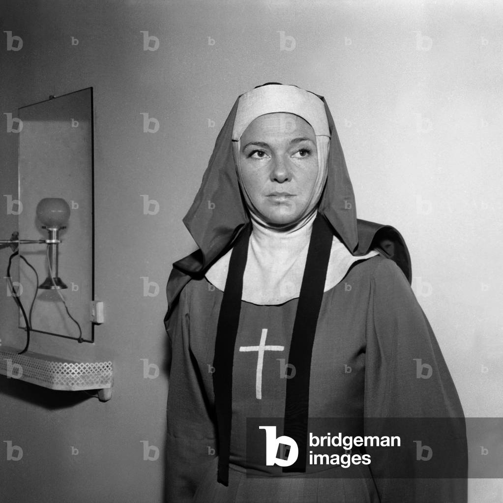 L'actrice française Sophie Desmarets (1922-2012) joue « Soeur Angele » sur le plateau du film dans les studios d'Epinay, 14 novembre 1955. (photo en b/w)
