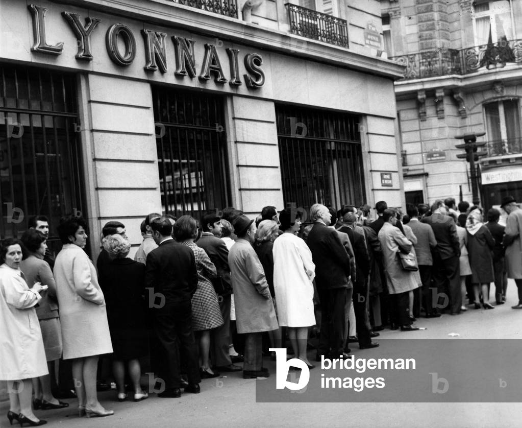 A queue of people waiting in front of a bank to process cash withdrawals, in fear of eventual closure, May 20, 1968 Rue De Miromesnil. (b/w photo)