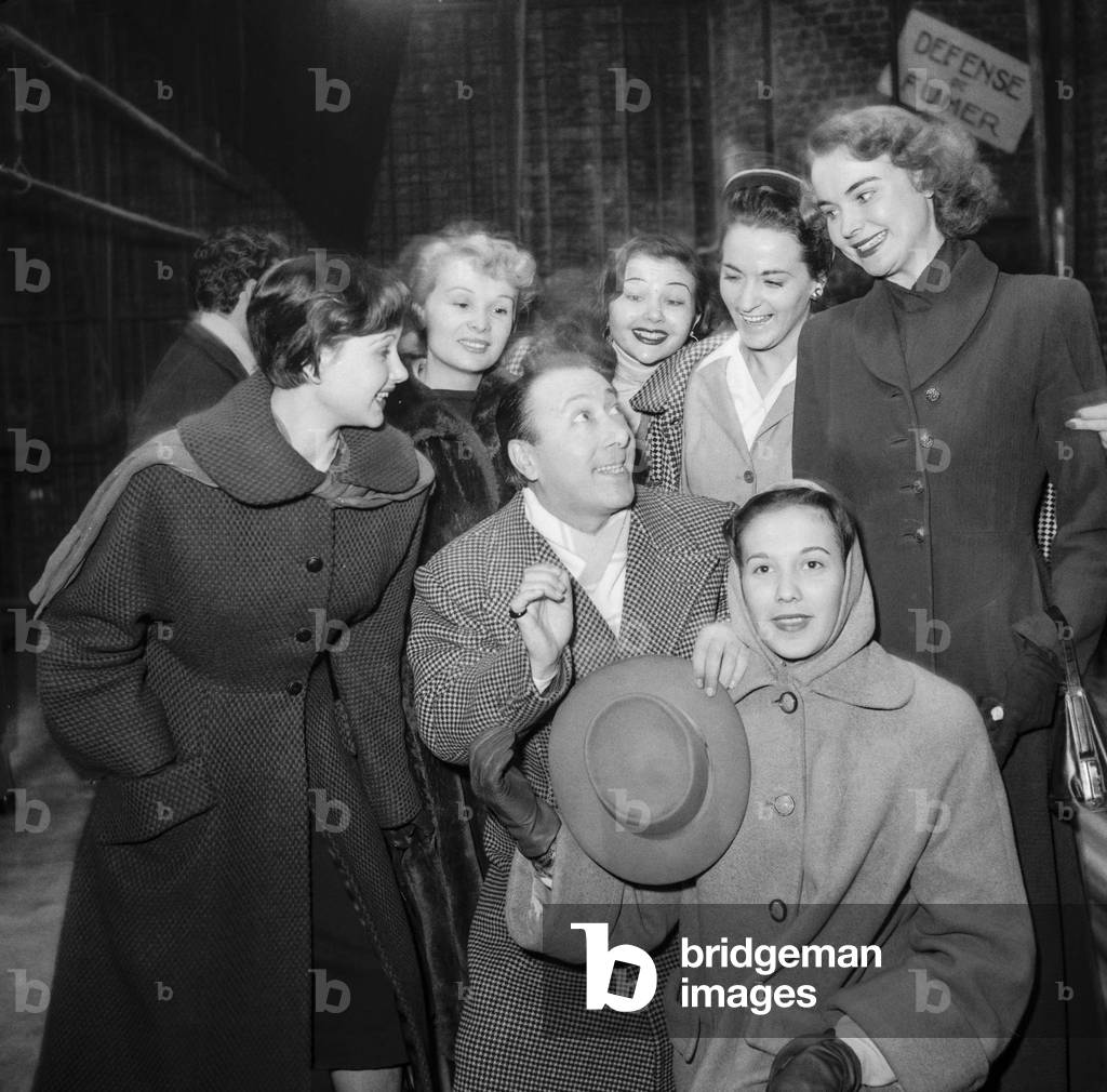 Italian comedian Erminio Macario with his girls, arriving at the Theatre de l'Etoile in Paris for his show 